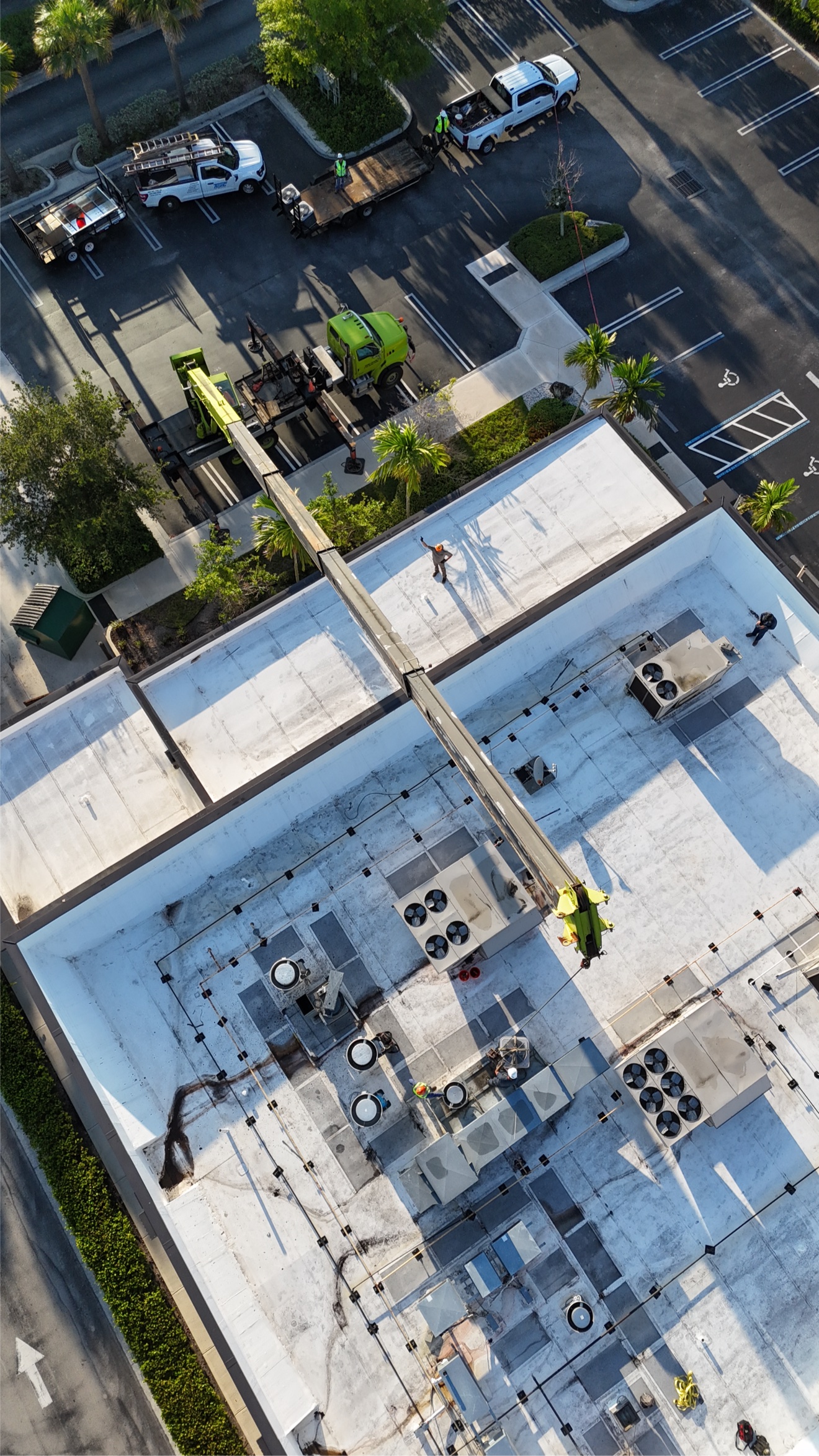 Aerial of a large commercial building with crane and HVAC units