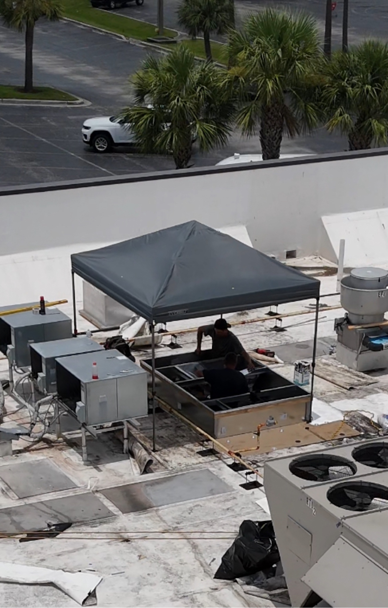 Commercial flat roof with HVAC units and workers