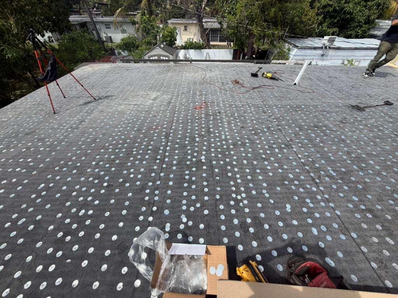 Flat roof base sheet with fastener plates, tripod on site