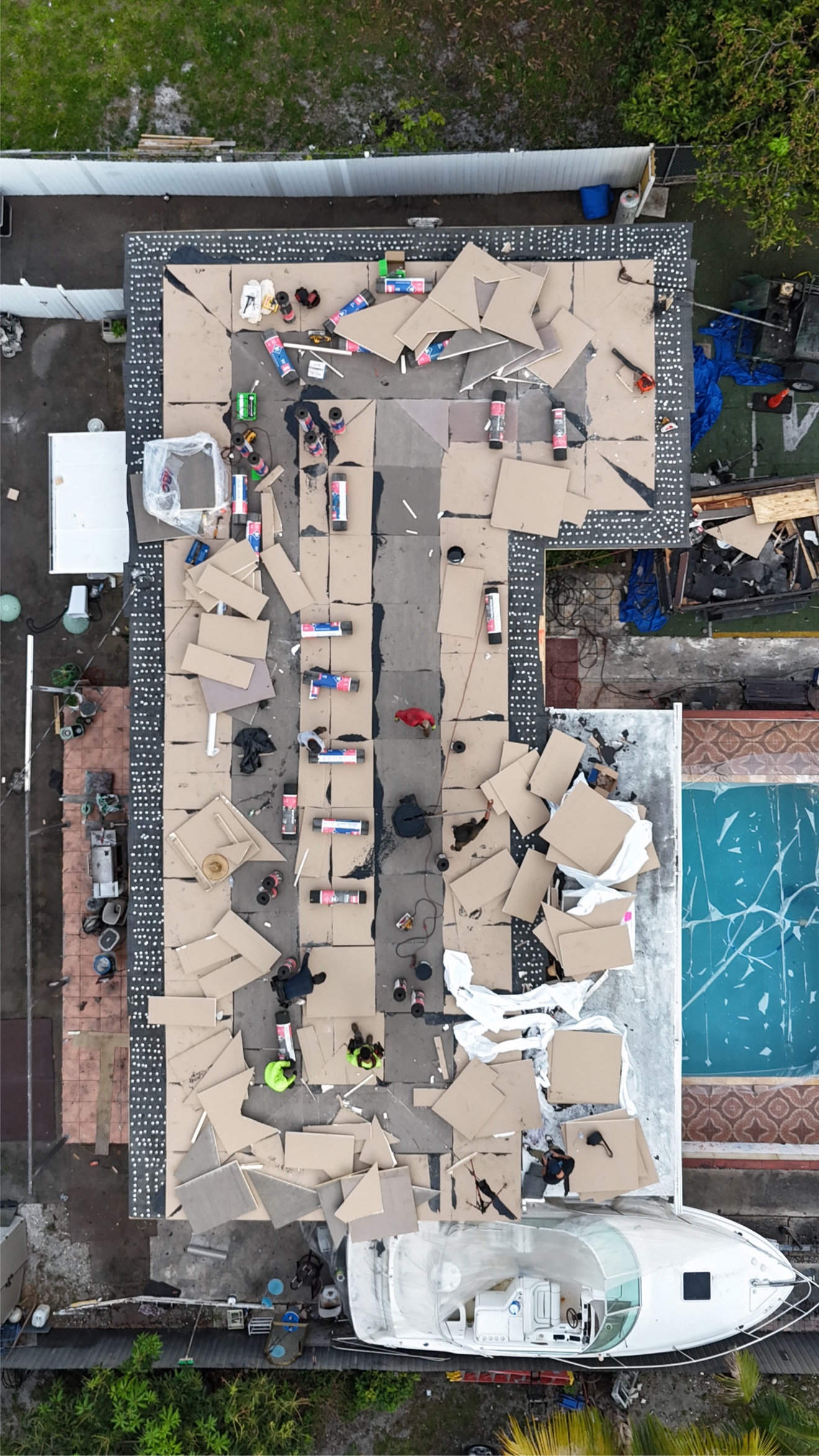 Aerial of insulation boards laid out on a flat roof with GAF rolls