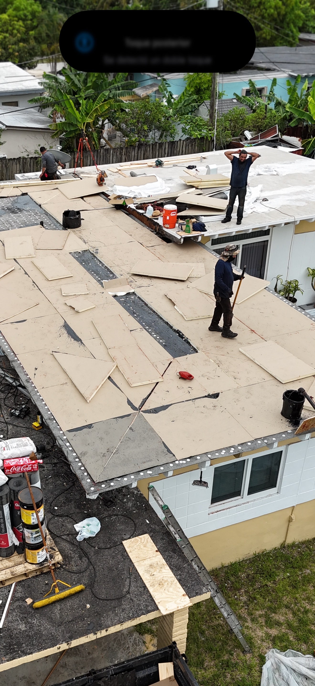 Aerial of crew installing insulation boards on a flat roof