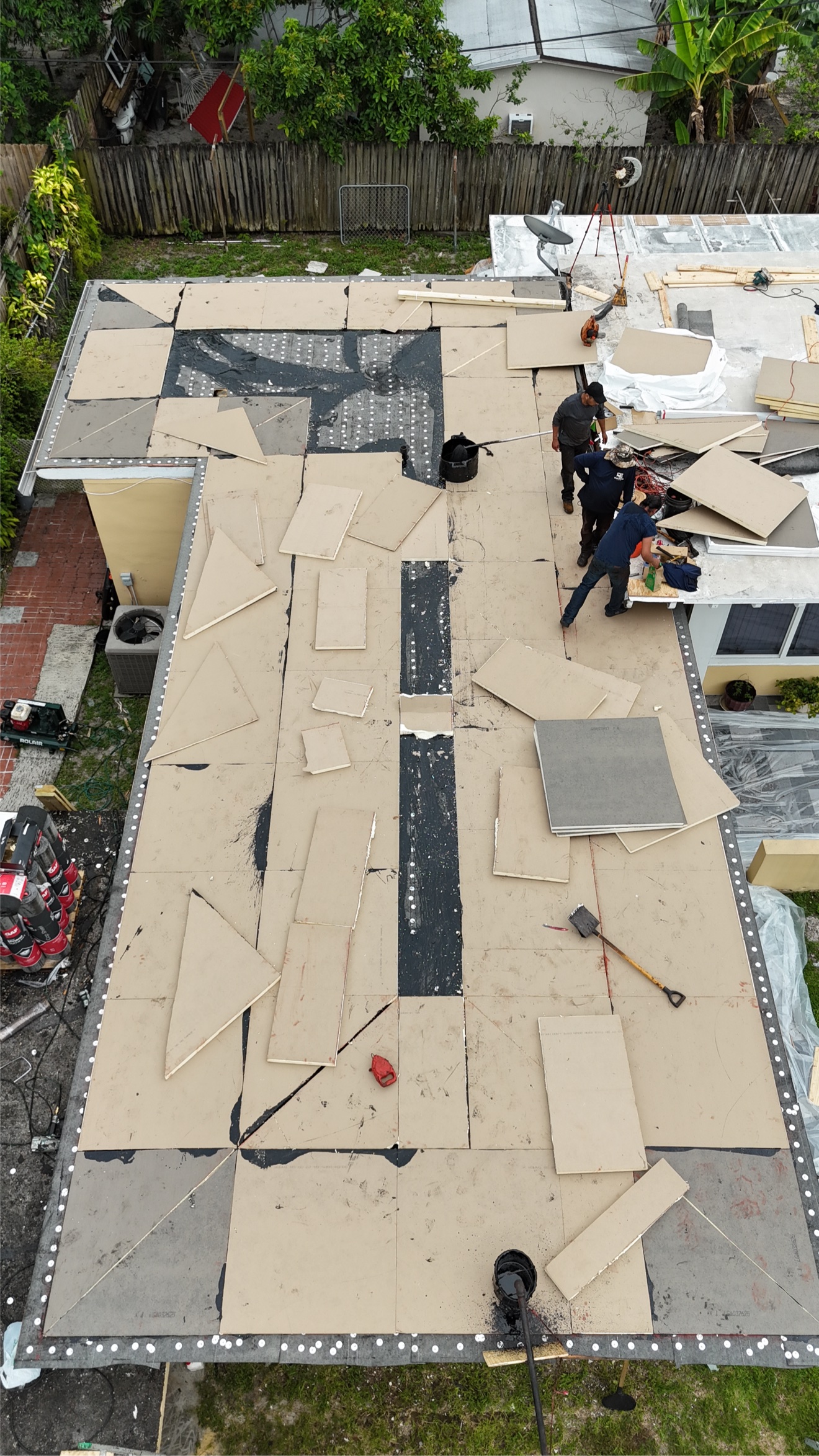 Aerial of flat roof insulation install with materials staged