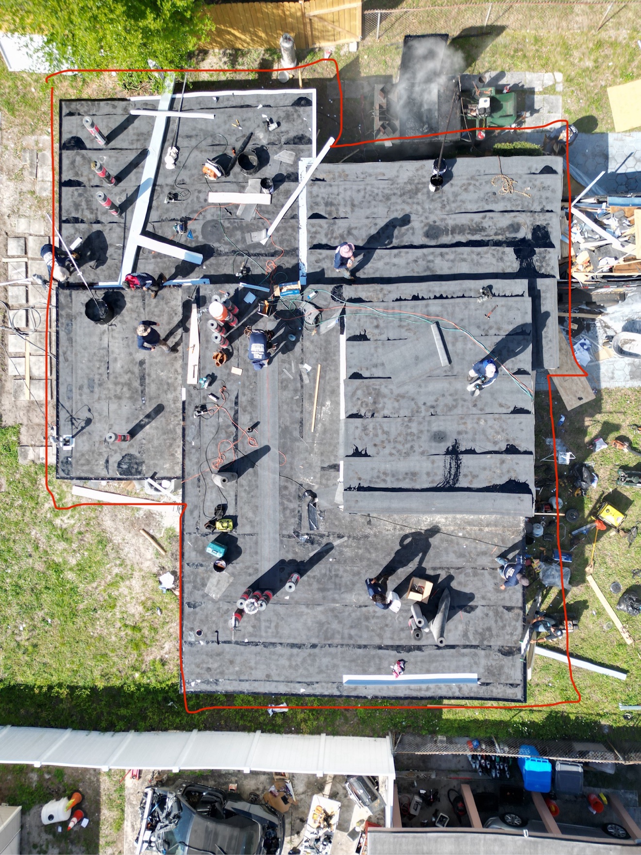 Aerial of flat roof tear-off in progress with old membrane