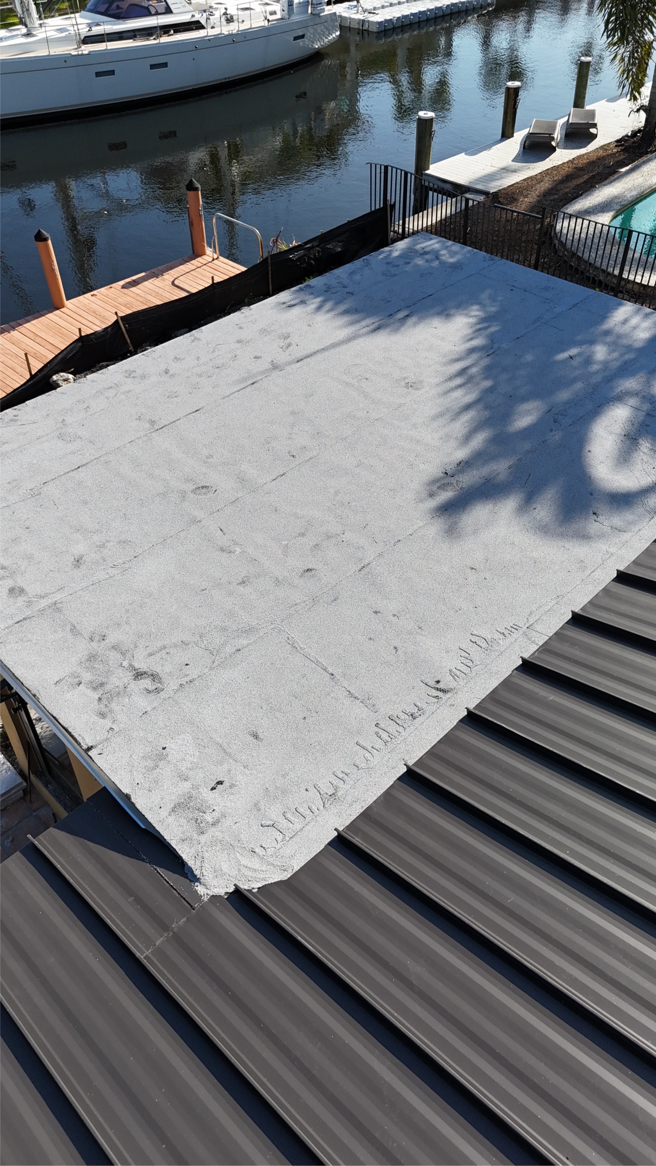 Flat roof section adjacent to a new metal roof on the waterfront