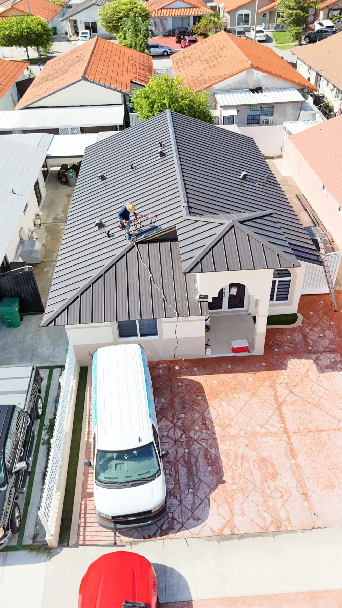 RE Builders worker on a finished metal roof, aerial view