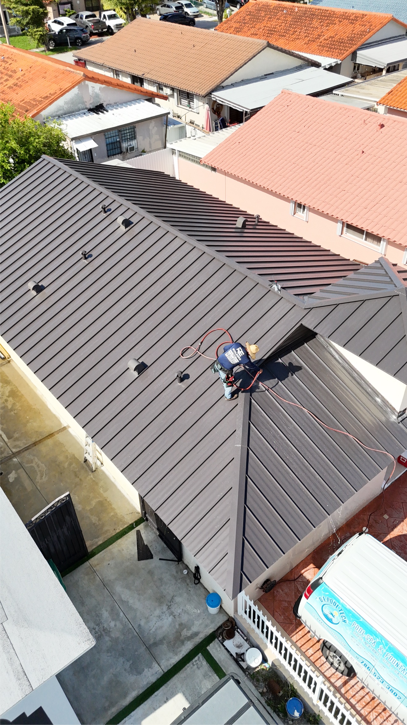Worker walking the ridge of a new metal roof