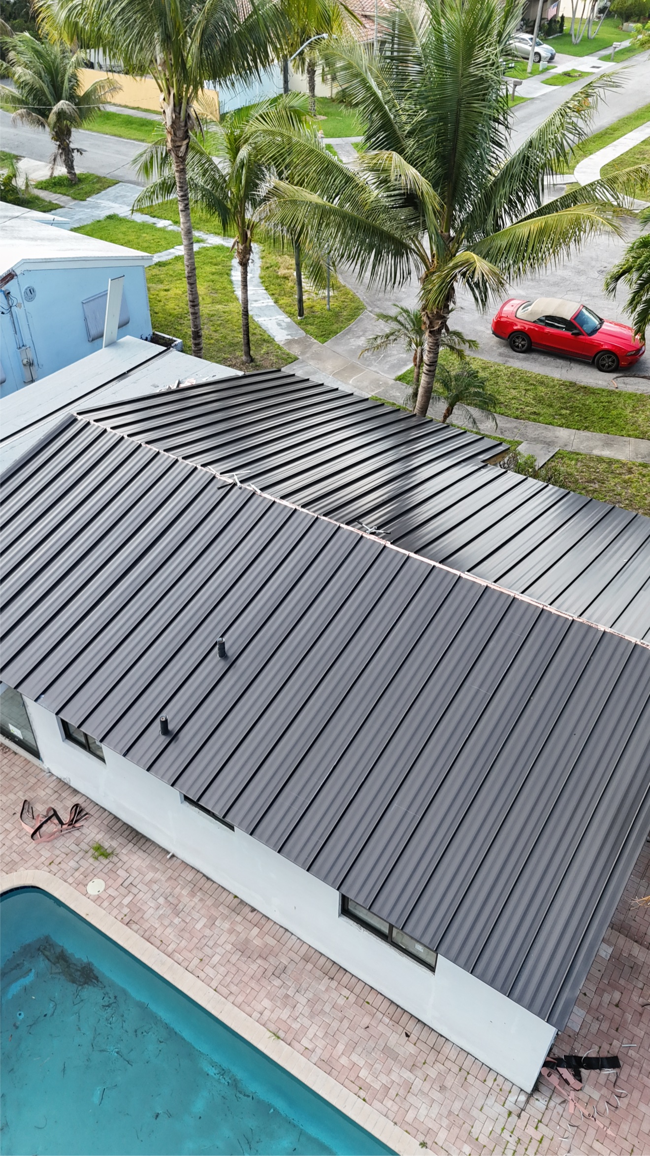 Aerial view of completed metal roof with pool
