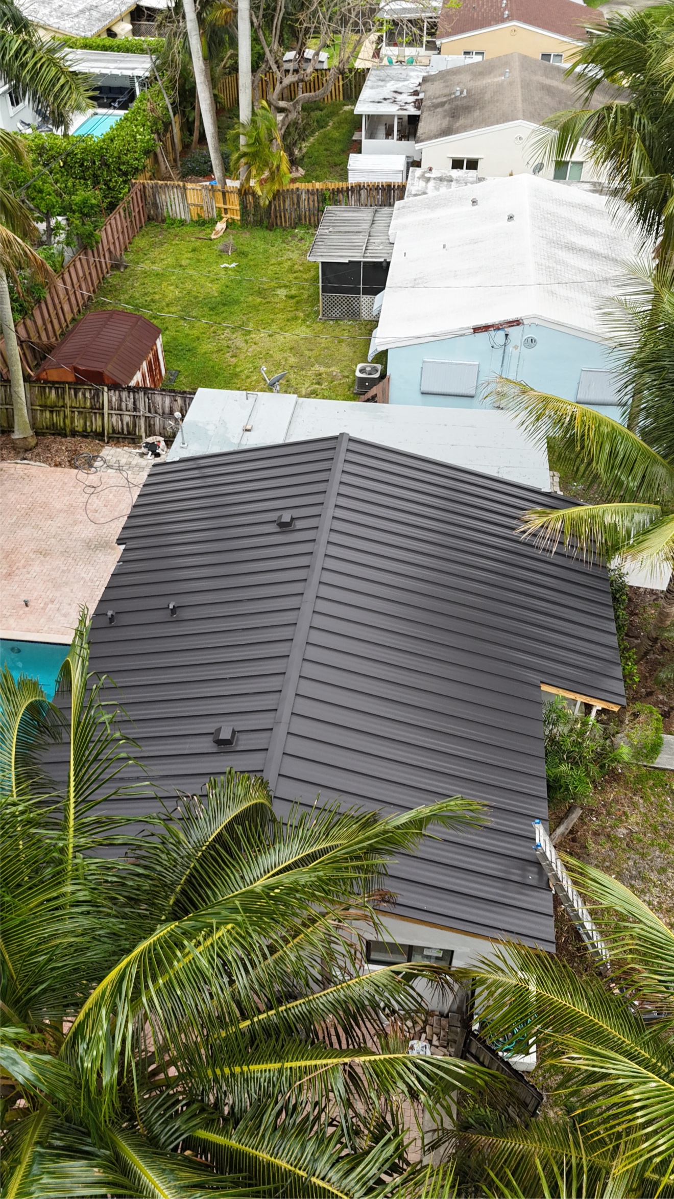 Top-down aerial of completed metal roof and pool