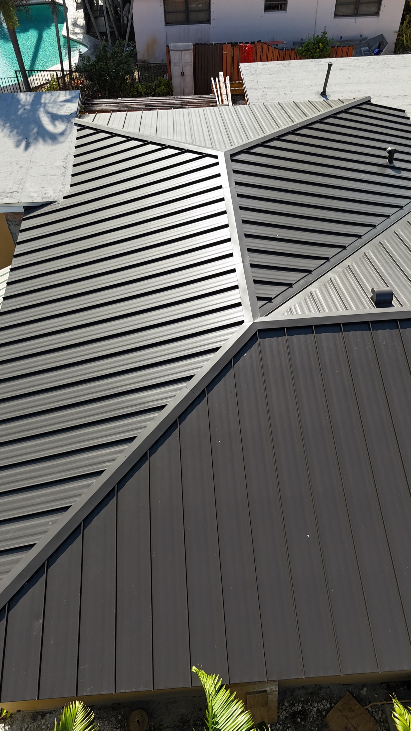 Aerial of finished metal roof with pool and fence