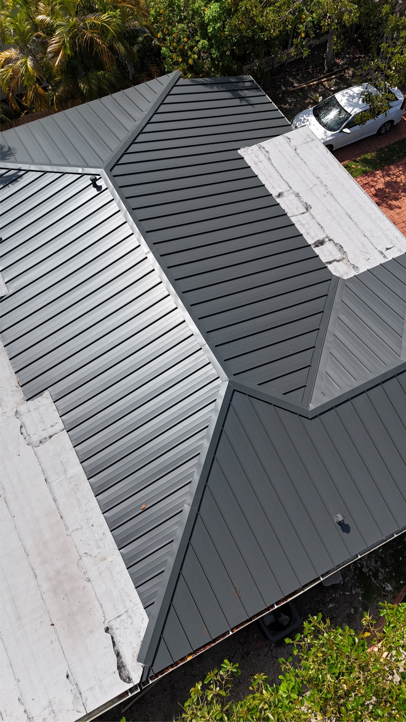 Aerial close-up of metal roof with flat white sections