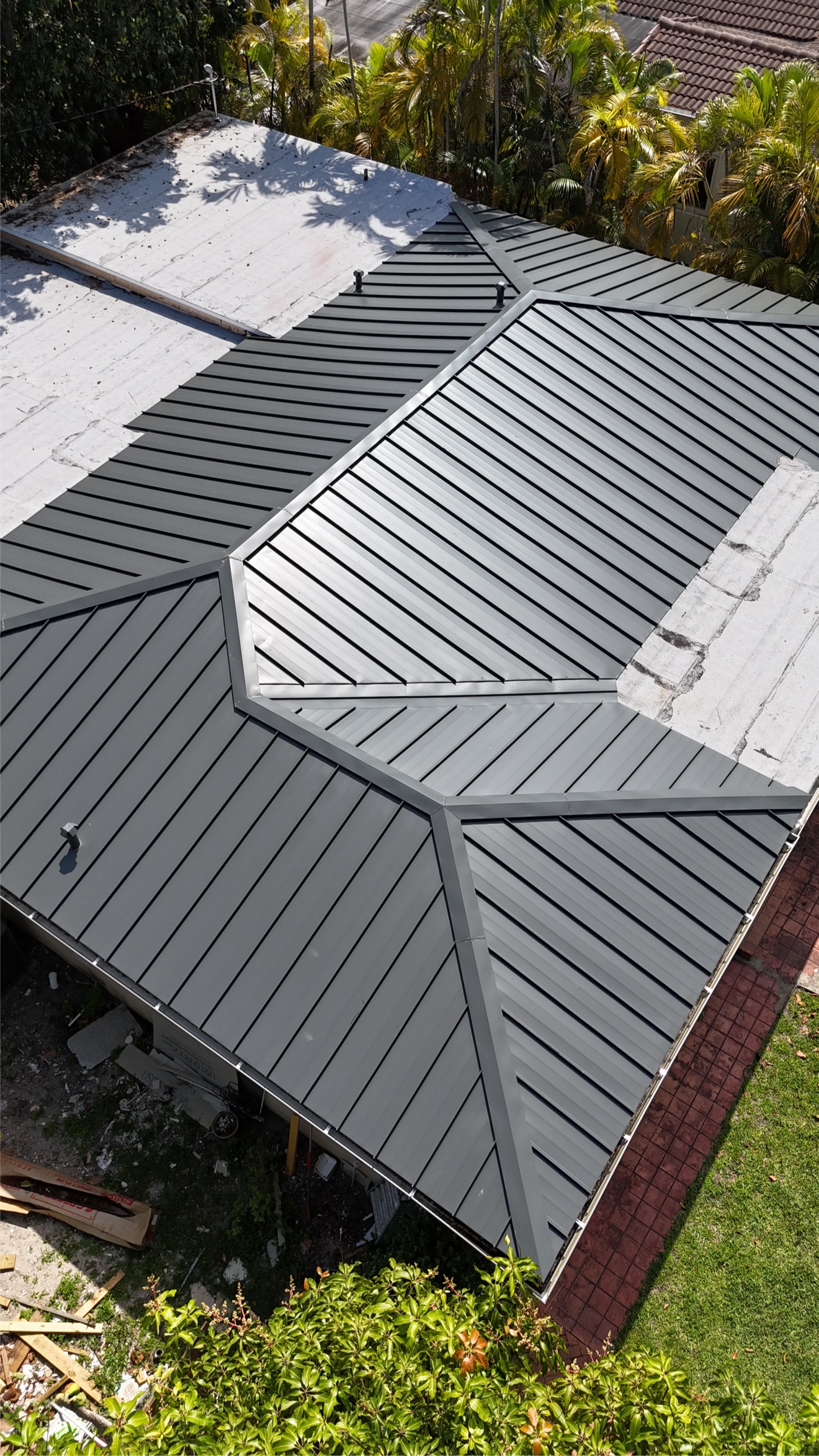 Top-down aerial of metal roof with flat white sections