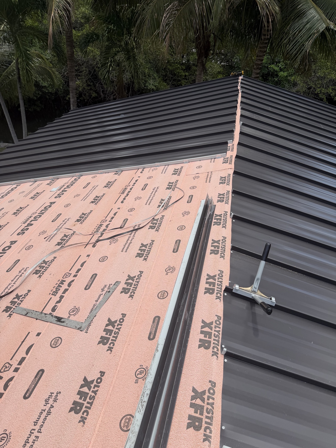 Close-up of installed dark bronze standing seam metal panels