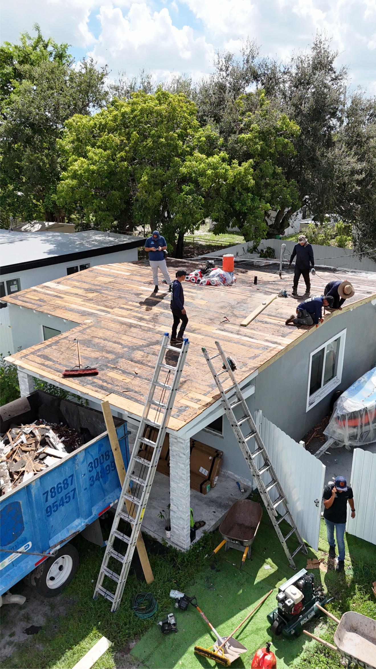 Crew tearing off the old roof before installing metal