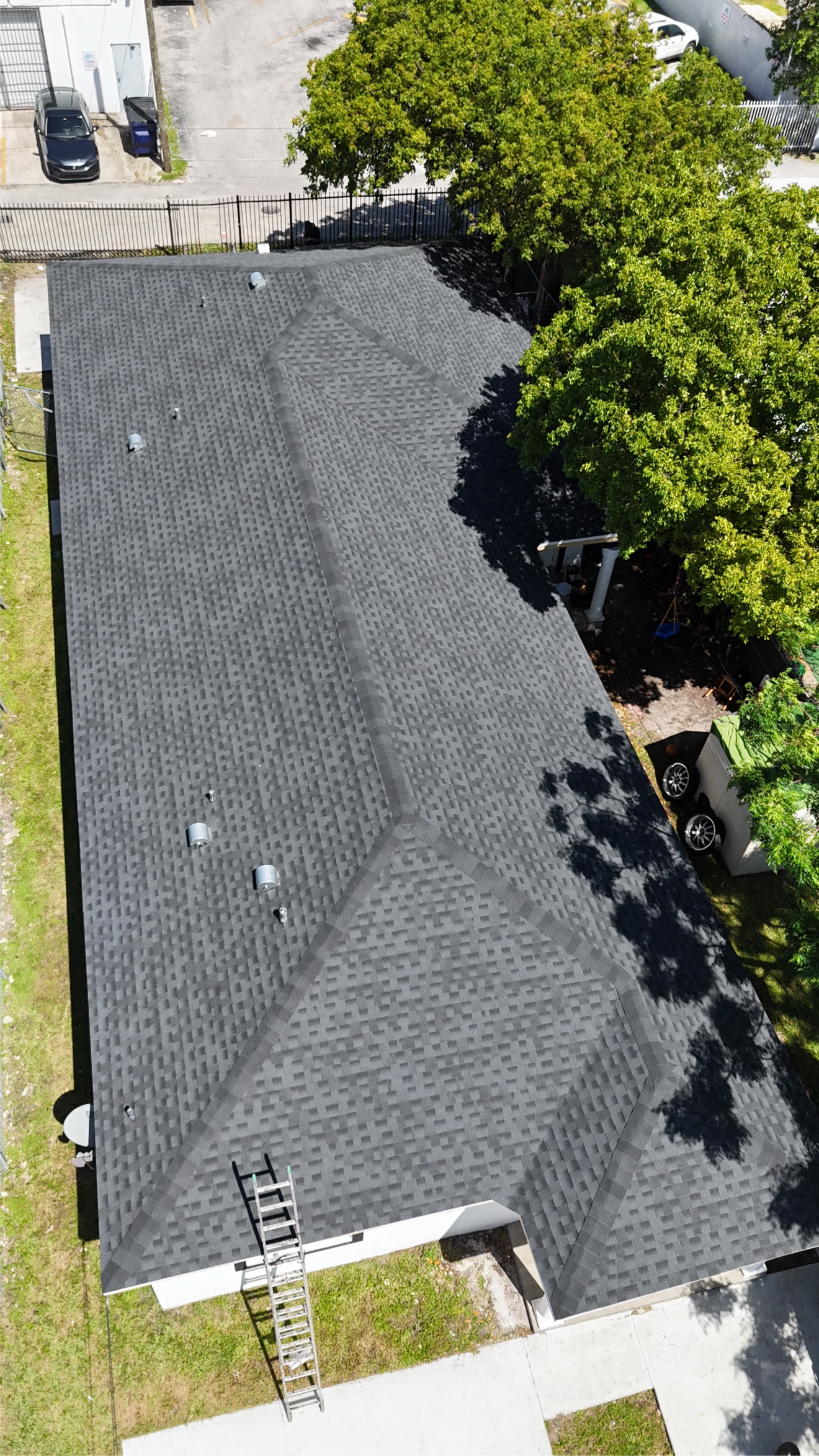 Aerial of a finished shingle roof with ladder