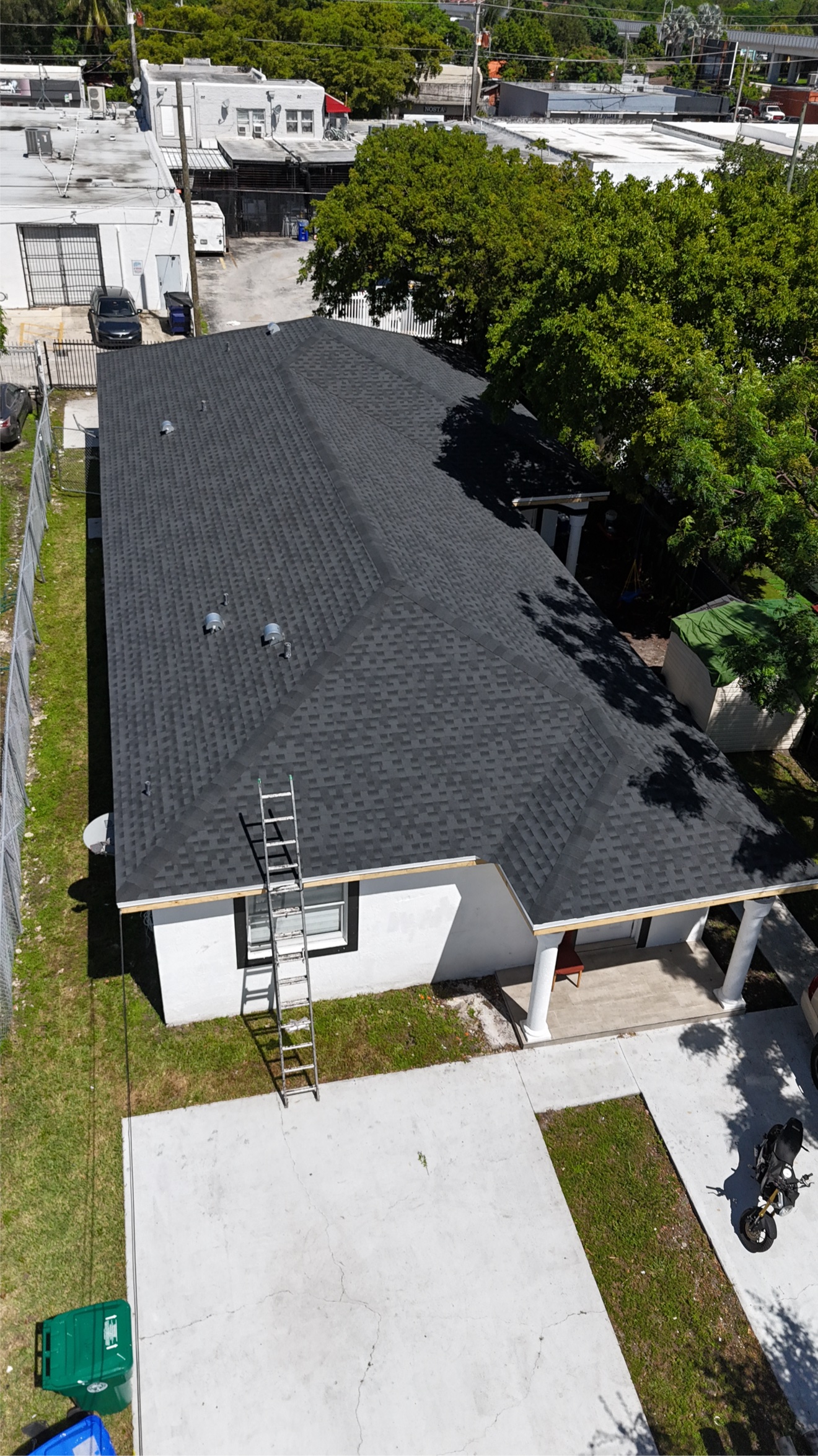 Aerial of a finished shingle roof with red car below