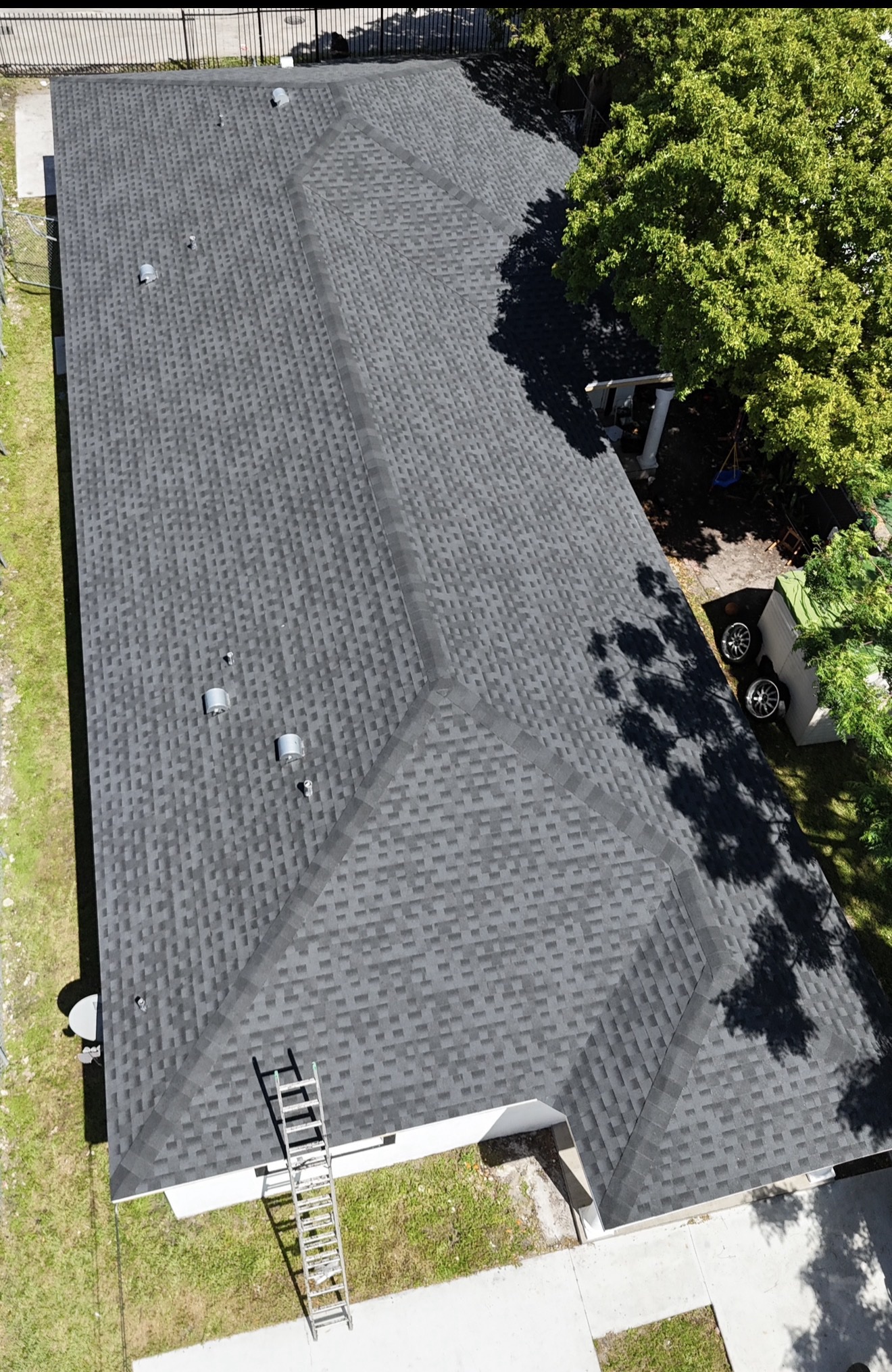 Aerial of a finished shingle roof on a white home