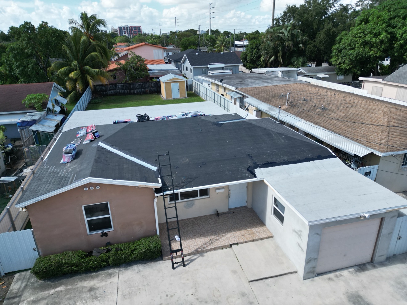 Aerial of a shingle roof job with a flat white section