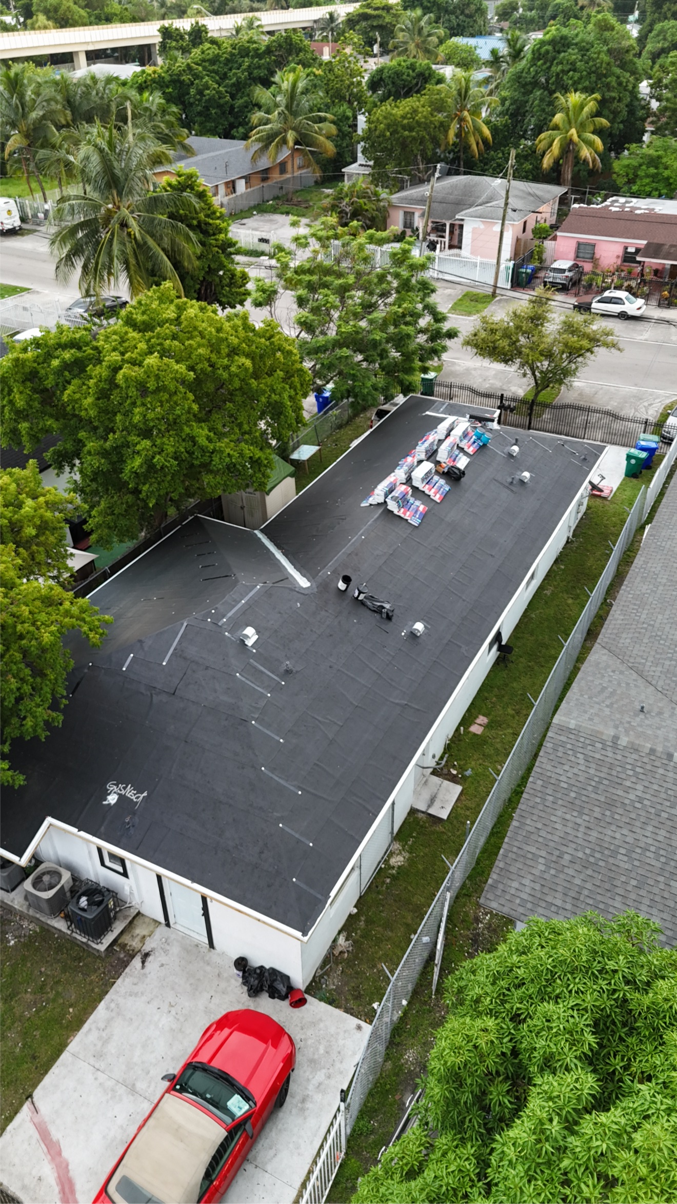 Aerial of a roof with underlayment and shingle bundles staged