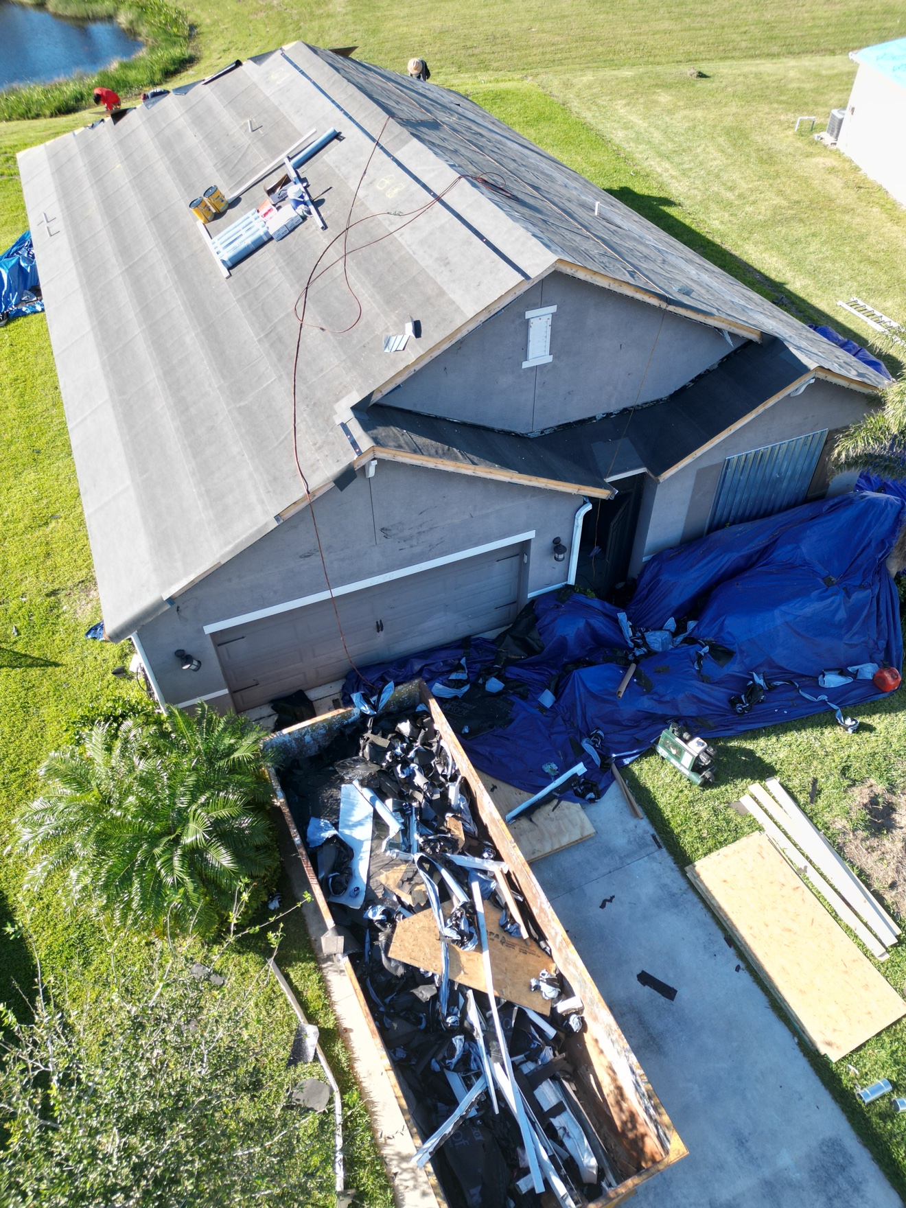 Aerial of shingle roof with underlayment and tear-off debris