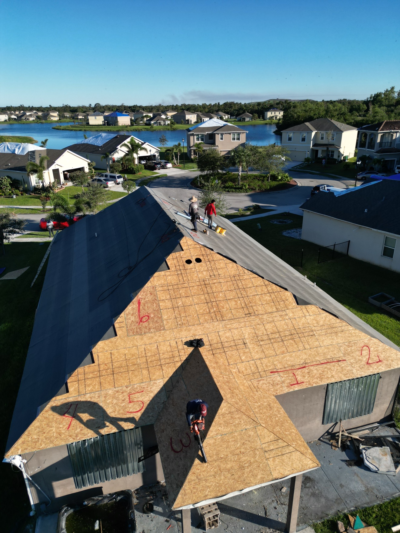 Aerial of shingle tear-off with new OSB deck and underlayment