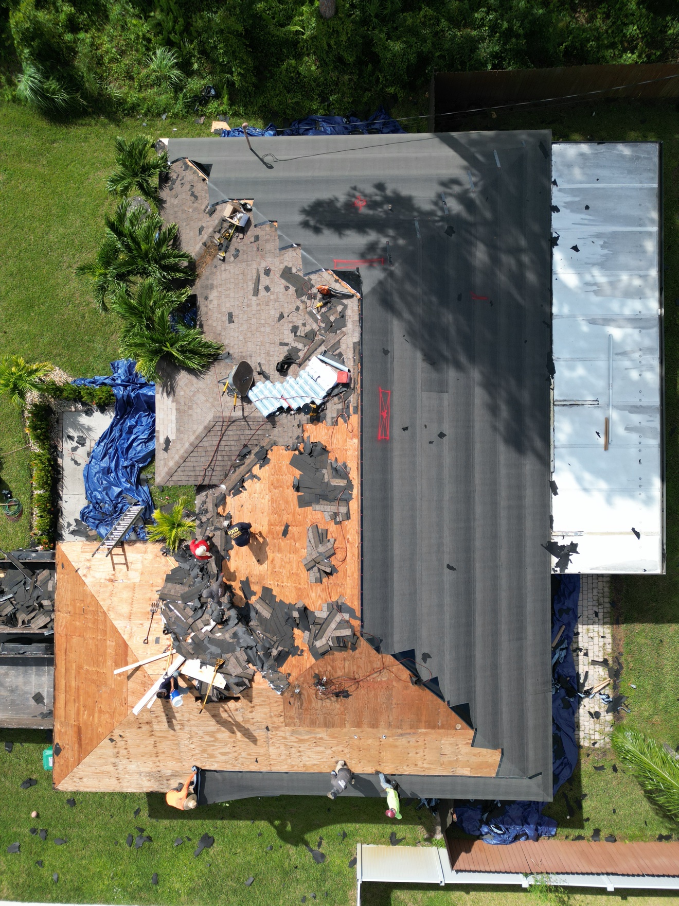 Top-down aerial of shingle tear-off in progress with underlayment