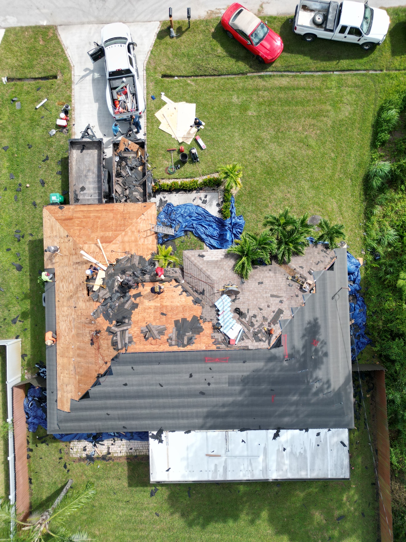 Top-down aerial of shingle tear-off with dump trailer