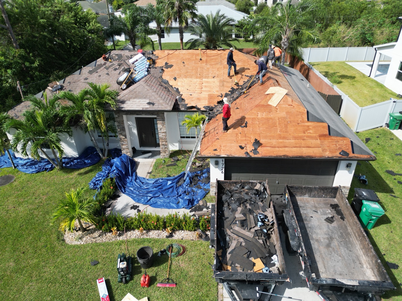 Aerial of shingle tear-off in progress on a house