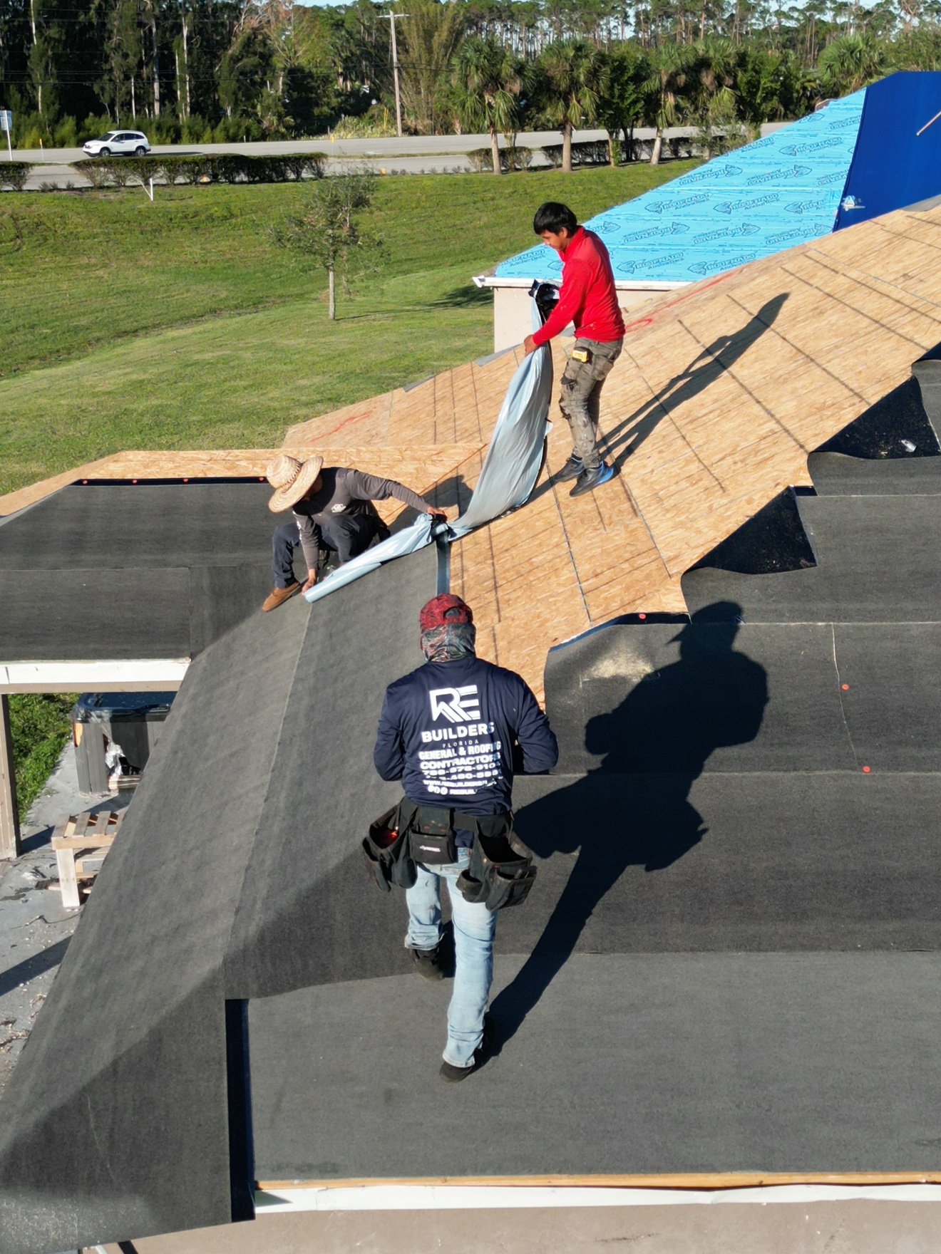 RE Builders crew installing underlayment on OSB deck