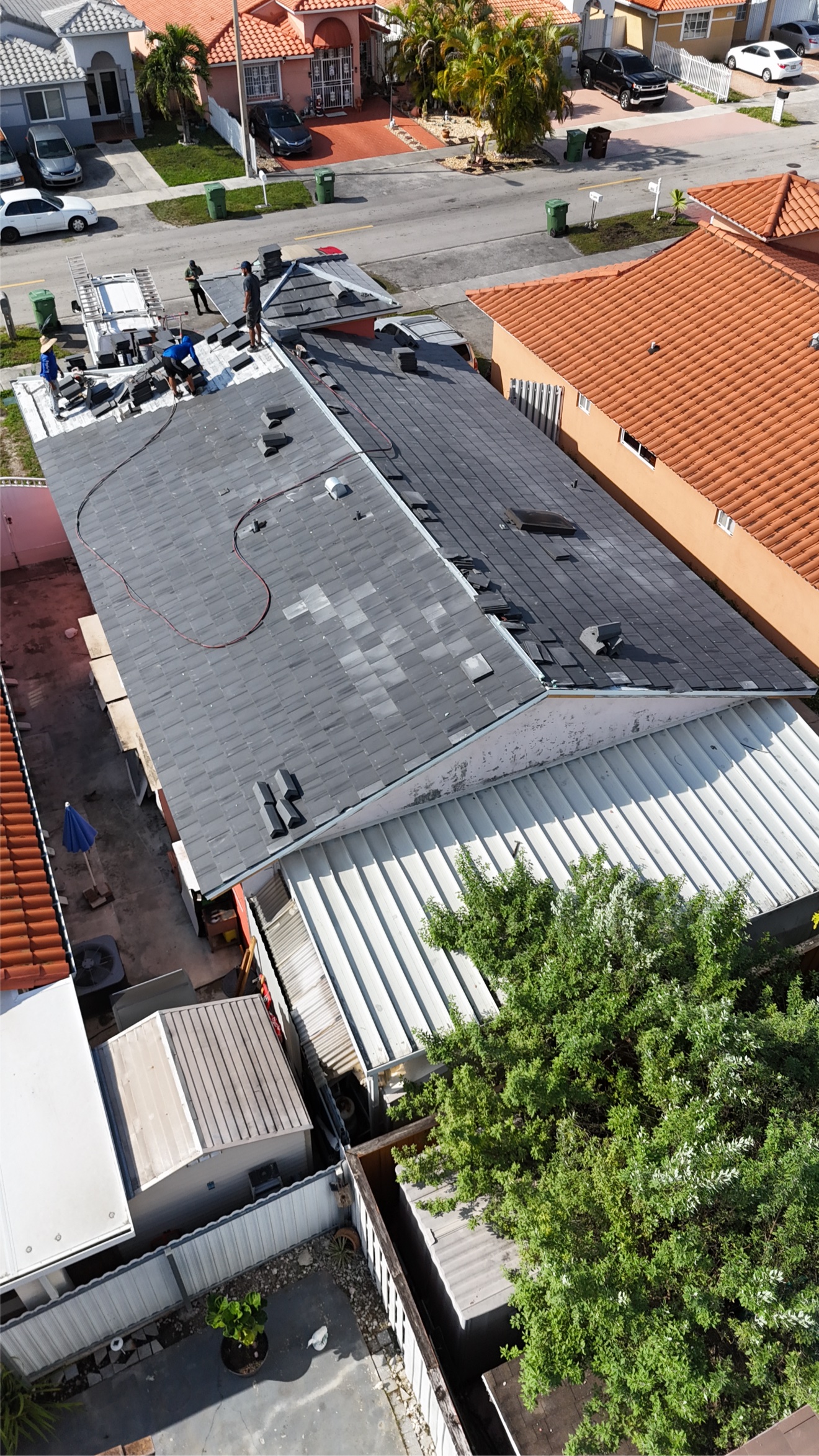 Aerial of crew on roof with tiles partially installed