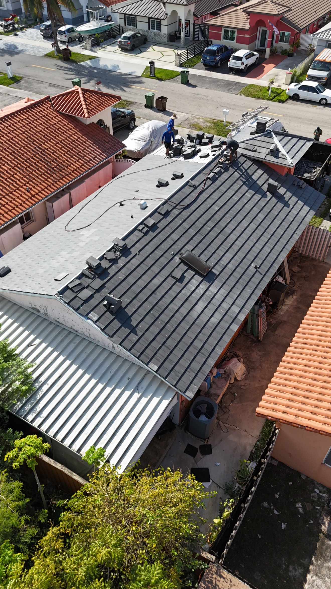 Aerial of crew installing tiles on the roof