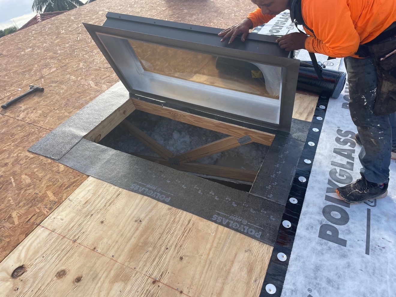 Worker installing skylight flashing for tile roof