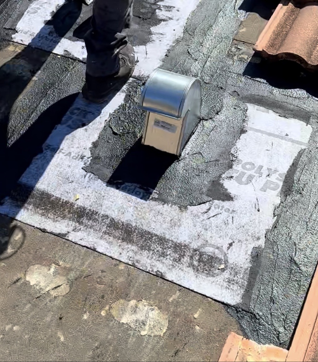 Close-up of metal vent flashing with hot-mop patching